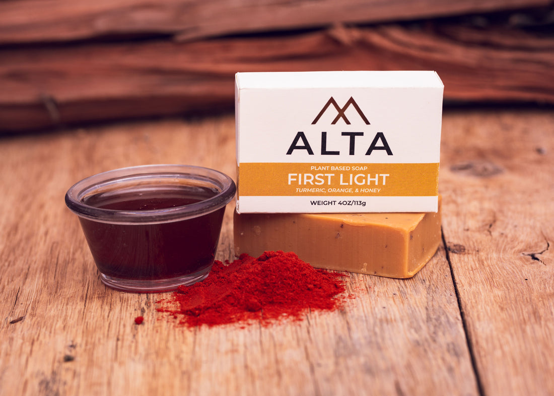 Bright turmeric powder spread on a wooden table, showcasing the plant-based antioxidants used in ALTA natural turmeric and honey soap for glowing skin