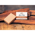 Evening Embers natural bar soap by Alta Body. A warm-toned, woodsy sandalwood cold-process soap bar placed on a natural wood surface.
