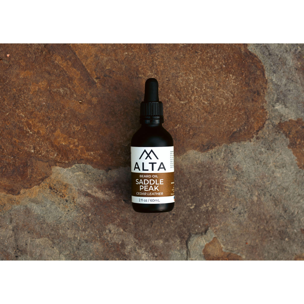 Alta Body Saddle Peak Premium Beard Oil in a 2oz glass dropper bottle. Cedar and Leather scented natural beard conditioner.